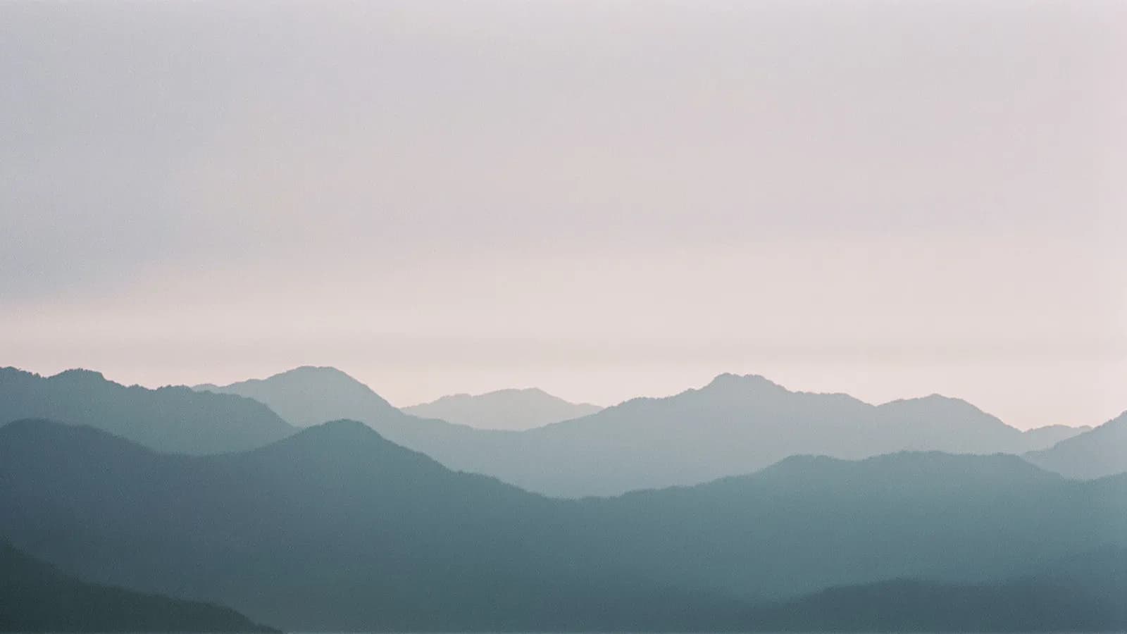 Mountain peaks emerging from low cloud in soft morning light