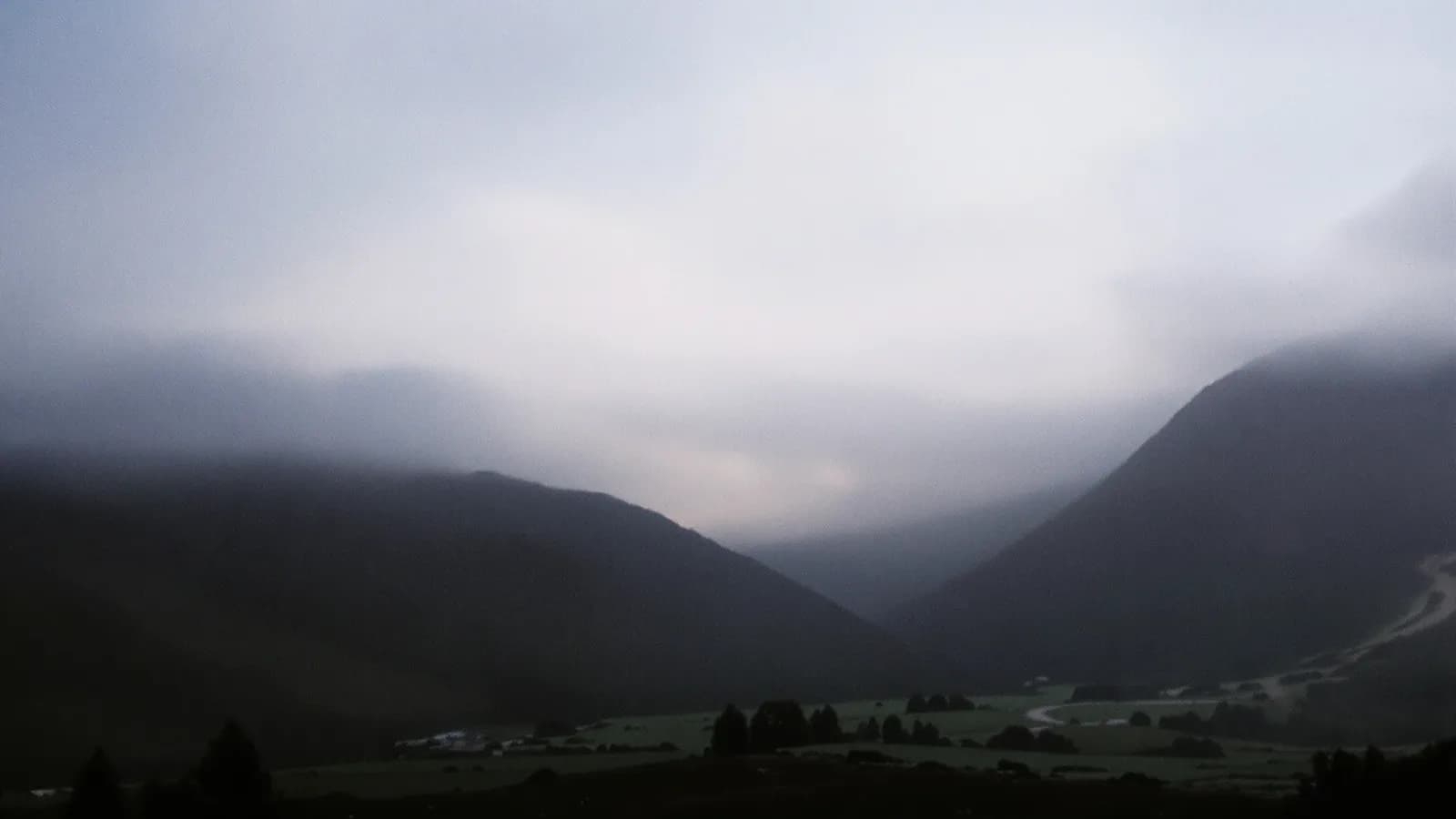 Alpine valley under drifting cloud in early light