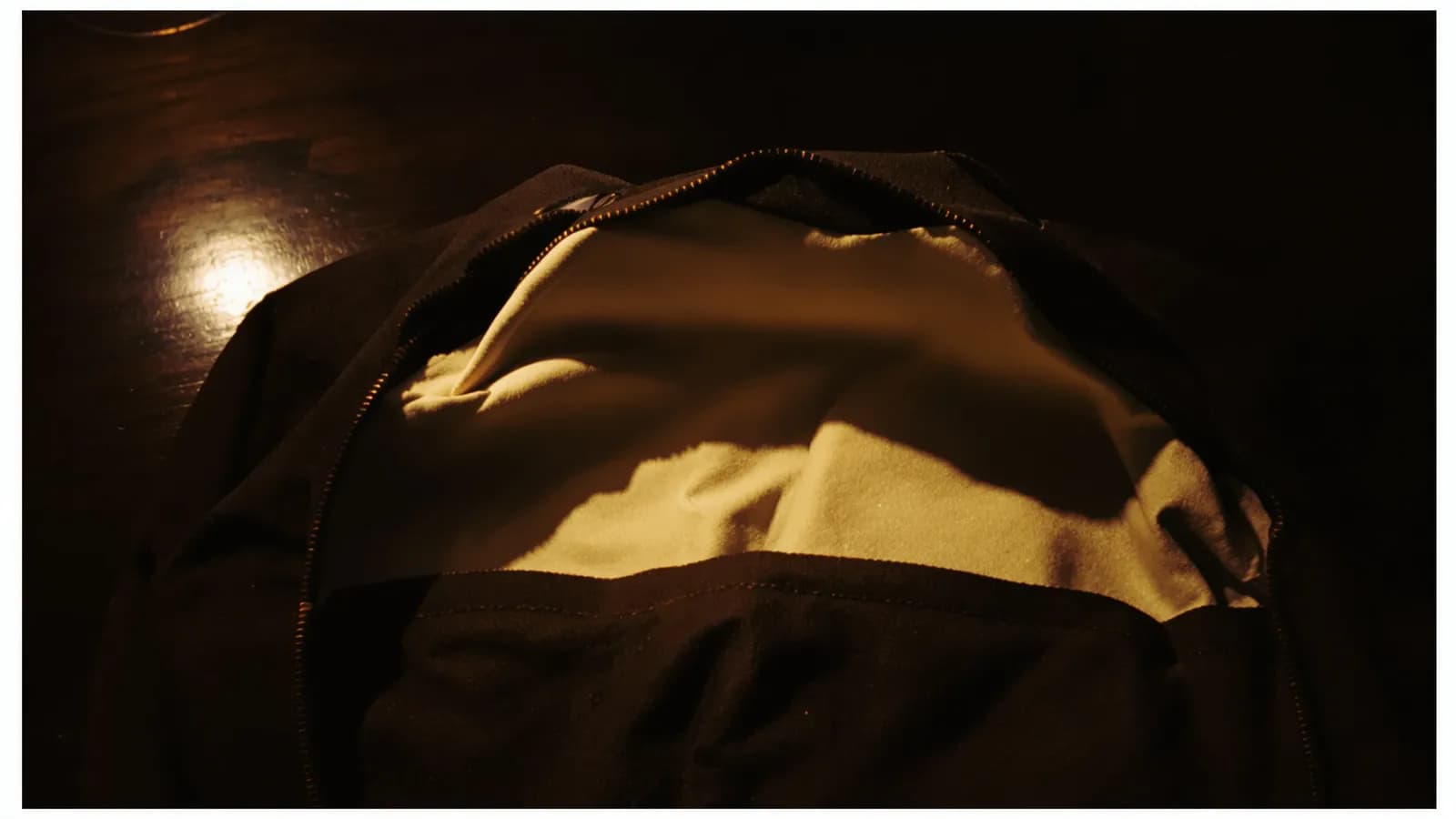 Empty coat pocket turned out on a wooden table in low light