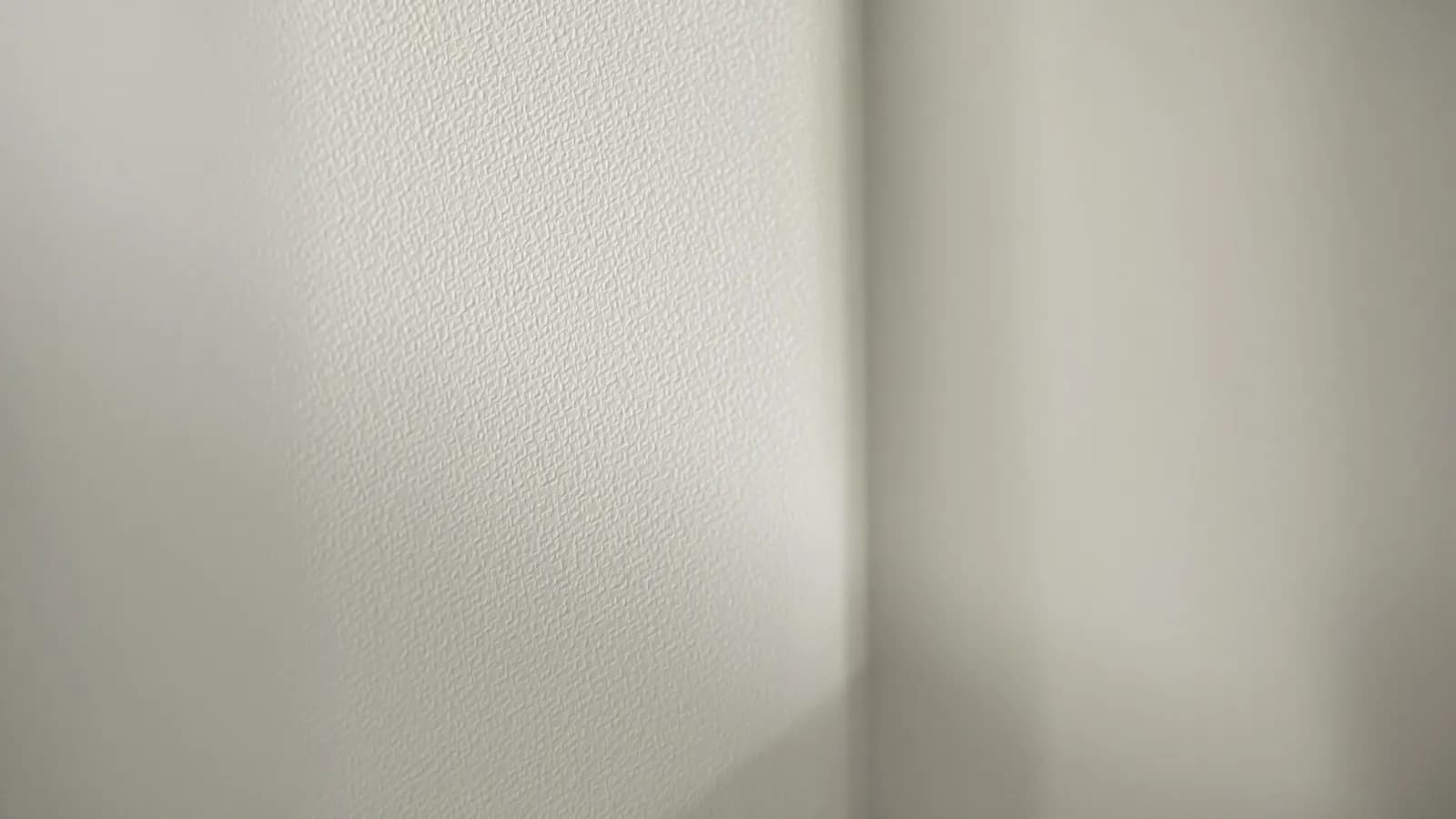 Close-up of a plain white studio wall corner with a soft shadow gradient